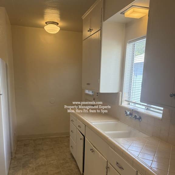 a bathroom with a tiled floor and white cabinets.