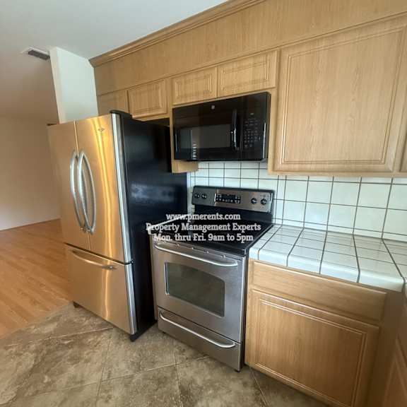 a kitchen with a stainless steel refrigerator, microwave, and oven.