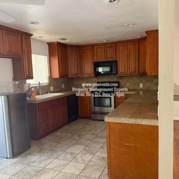a kitchen with wooden cabinets and a tile floor.