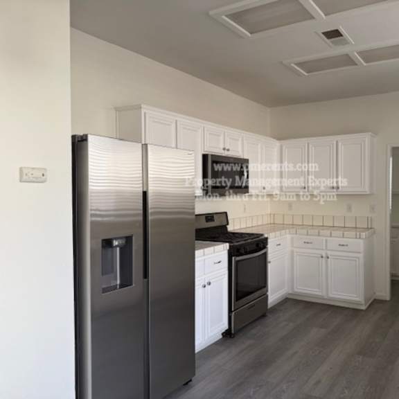 a kitchen with a refrigerator, oven, and microwave.