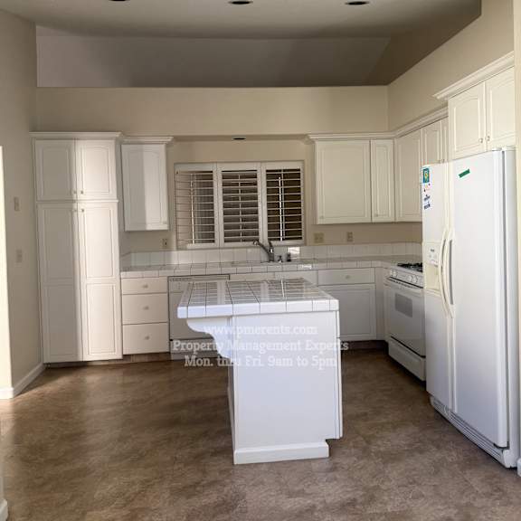 a kitchen with white appliances and cabinets.