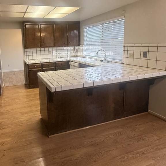 a kitchen with wooden cabinets and a tiled countertop.