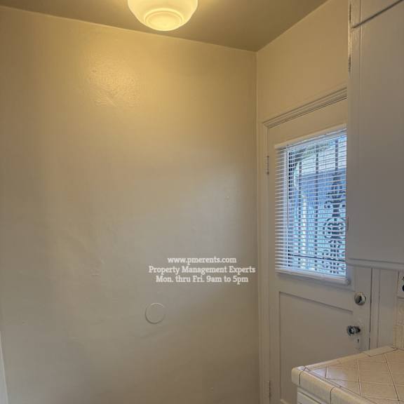 a bathroom with a white vanity and a window with blinds.