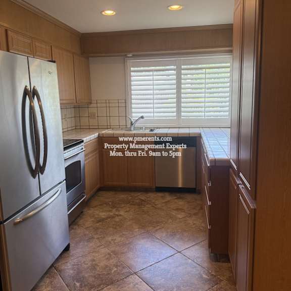 a kitchen with a refrigerator, stove, and sink.