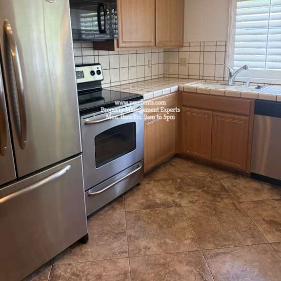 a kitchen with a stainless steel refrigerator and oven.