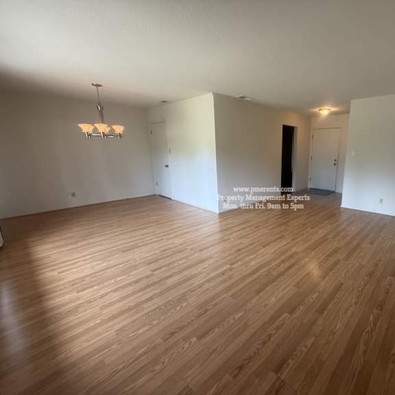 a room with wooden flooring and white walls.