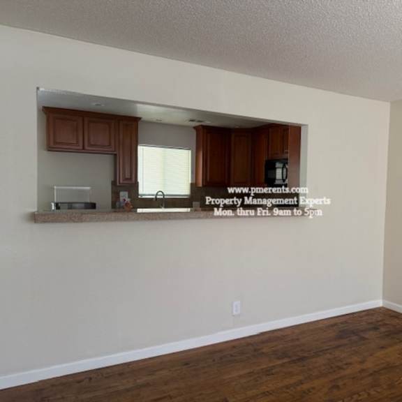 a room with wooden floors and a wall with a mirror and a sign that says "www.propertymanagement.com".