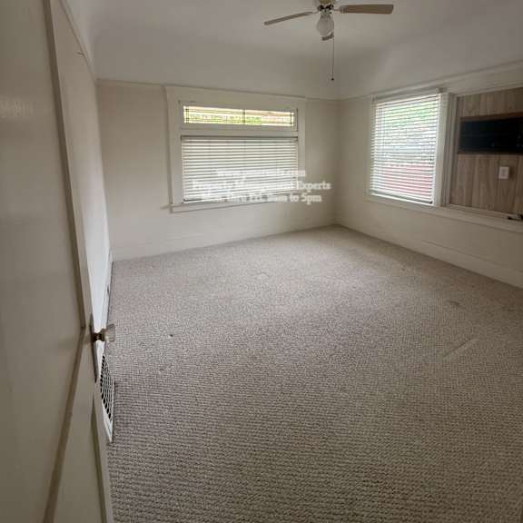 a room with a ceiling fan and carpeted floor.