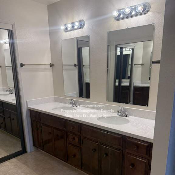 a bathroom with a sink, mirror, and lights.