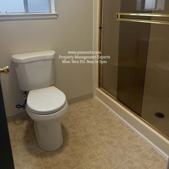 a white toilet in a bathroom with a glass shower door.