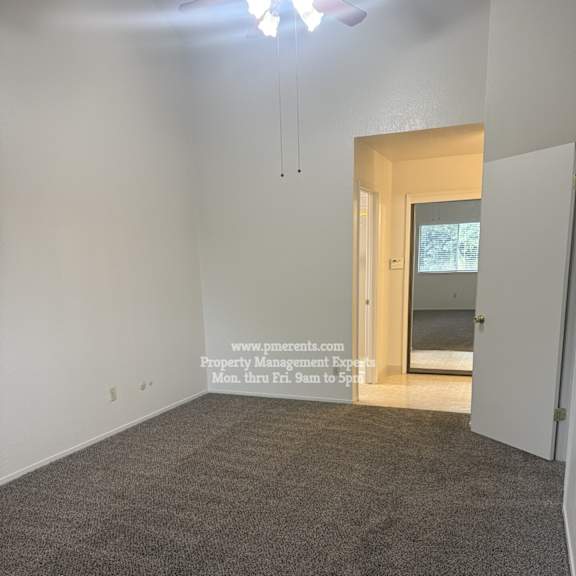 a room with a carpeted floor and a door leading to another room.