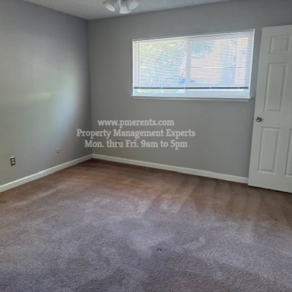 a room with a window and a door, and a wall with a website address written on it.