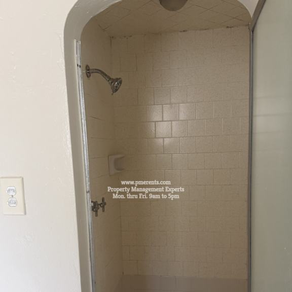 a shower stall with a door that is open.