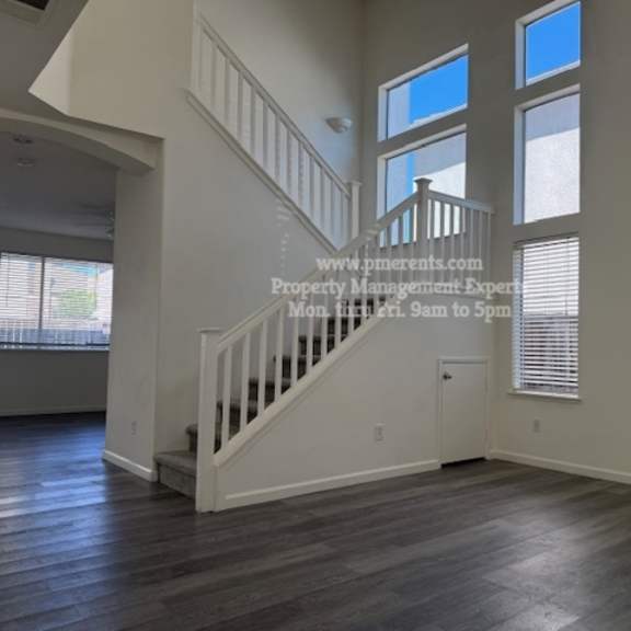 a spacious room with a staircase leading to the upper level.