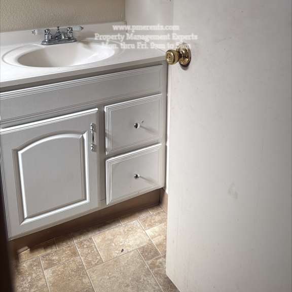 a bathroom with a sink, mirror, and cabinets.