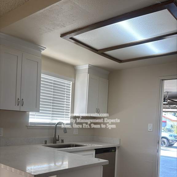 a kitchen with white cabinets and a tiled floor.