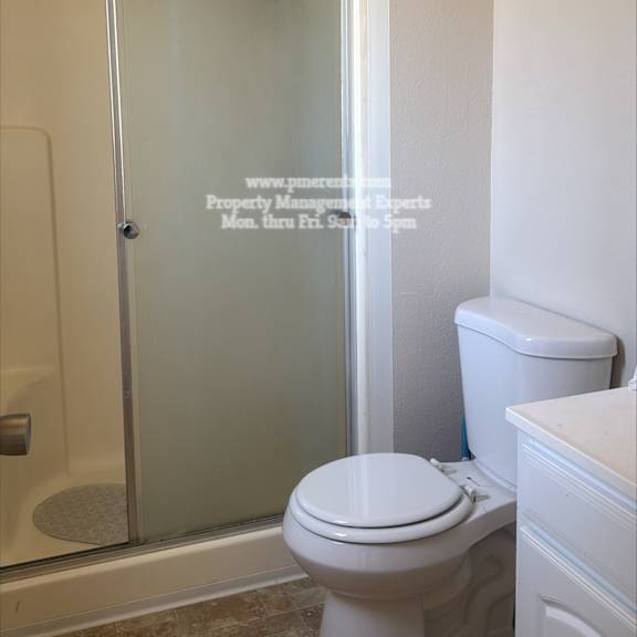 a white toilet in a bathroom with a glass shower door.