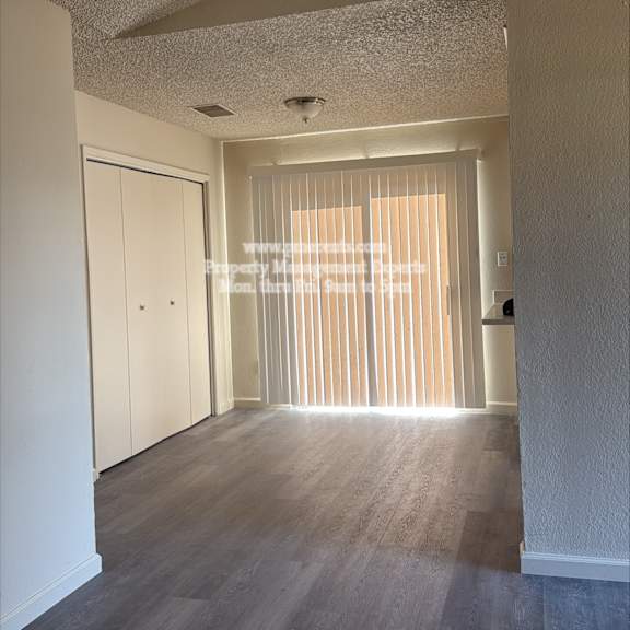 a long hallway with a door at the end.
