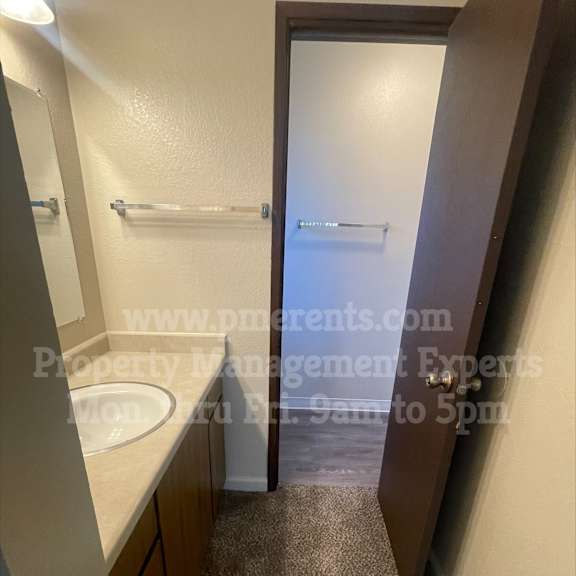 a bathroom with a sink, mirror, and towel rack.