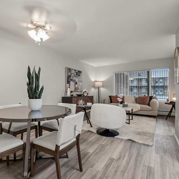 a well-lit, modern dining room with a table set for four.
