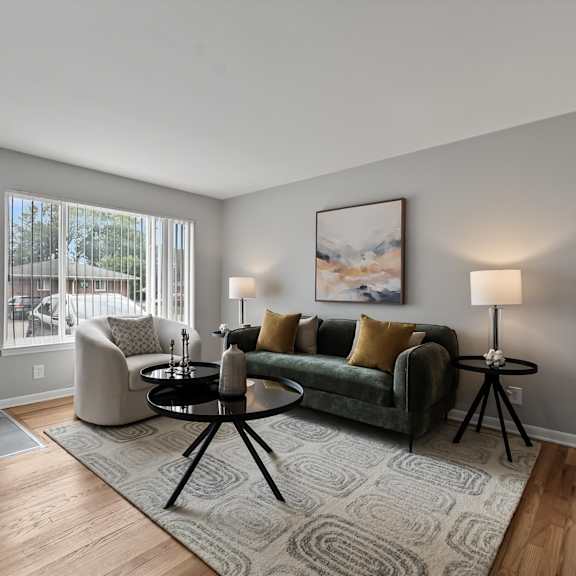 a living room with a green couch and a grey rug.