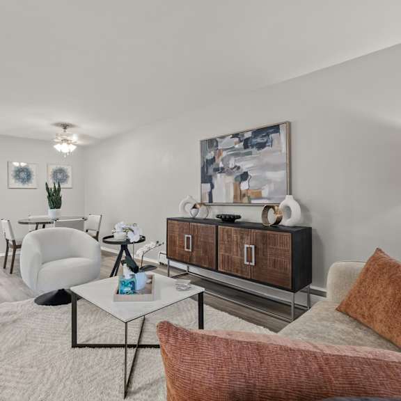 a living room with a white sofa, a coffee table, and a painting on the wall.