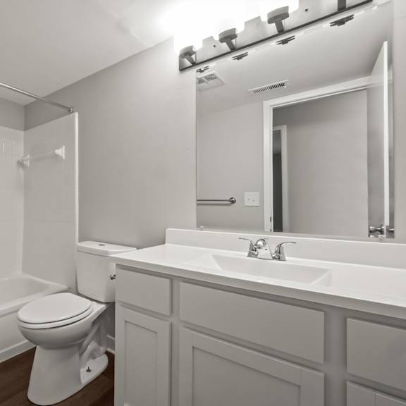 a white bathroom with a toilet, sink, and bathtub.