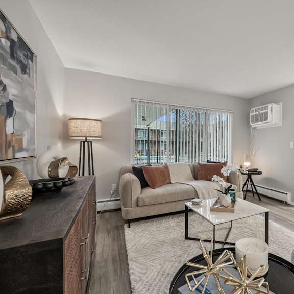 a living room with a couch, a coffee table, and a large mirror.