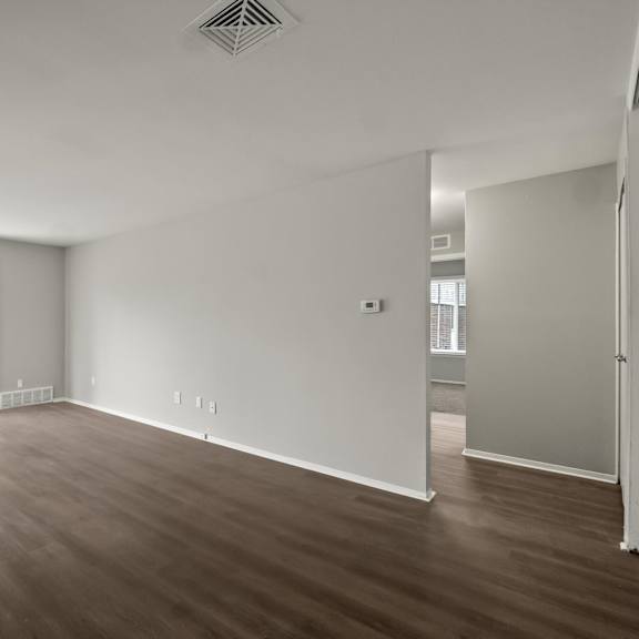a large empty room with wooden floors and white walls.