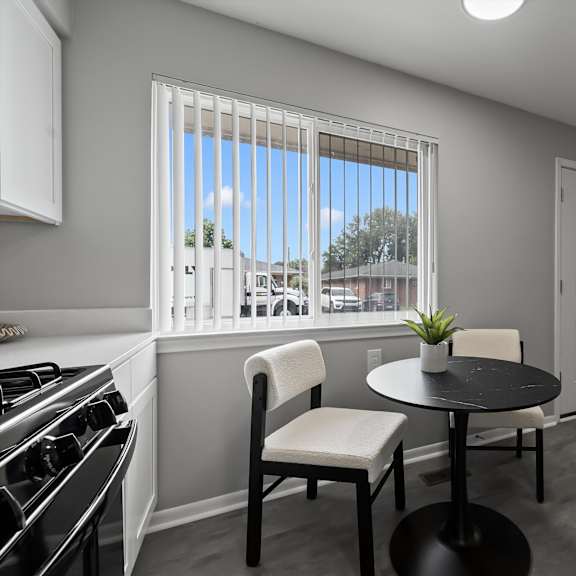a modern kitchen with a black table and white chairs.