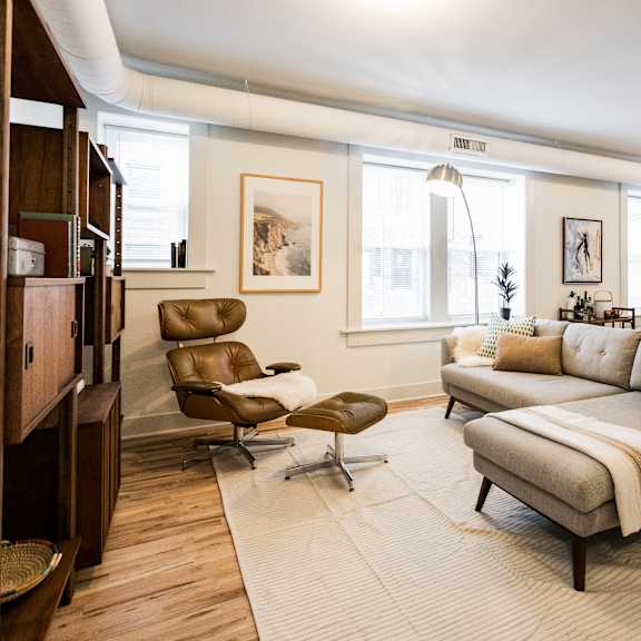 a living room with a brown leather chair and a white couch.