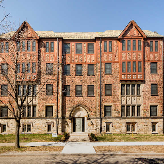 a large red brick building with a tree in front of it.