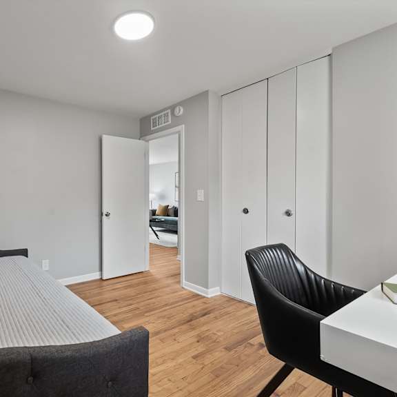 a bedroom with a bed, chair, and wardrobe.