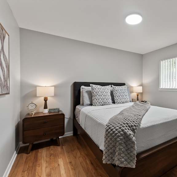 a bedroom with a bed, nightstand, and window.