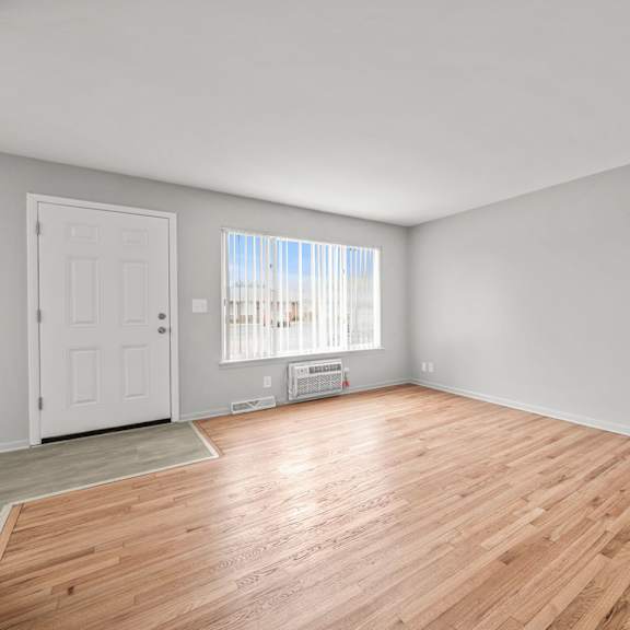 a bedroom with hardwood floors and grey walls