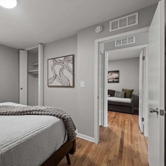 a bedroom with a large bed and a view of the backyard through the window.