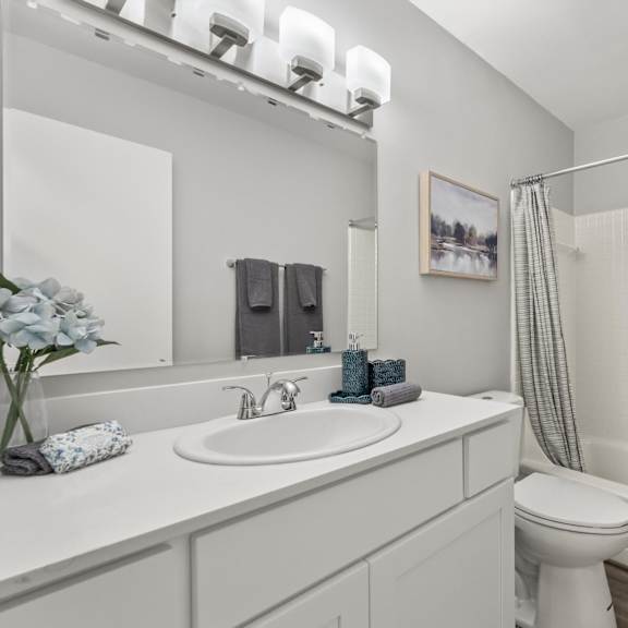 a white bathroom with a toilet, sink, and bathtub.
