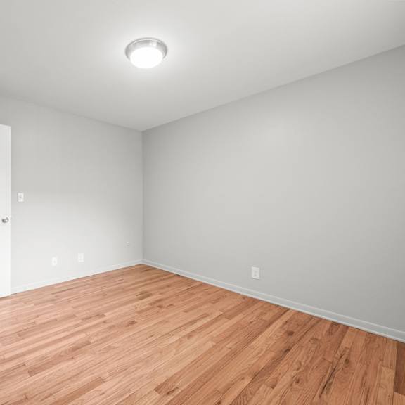 a bedroom with grey walls and a wooden floor
