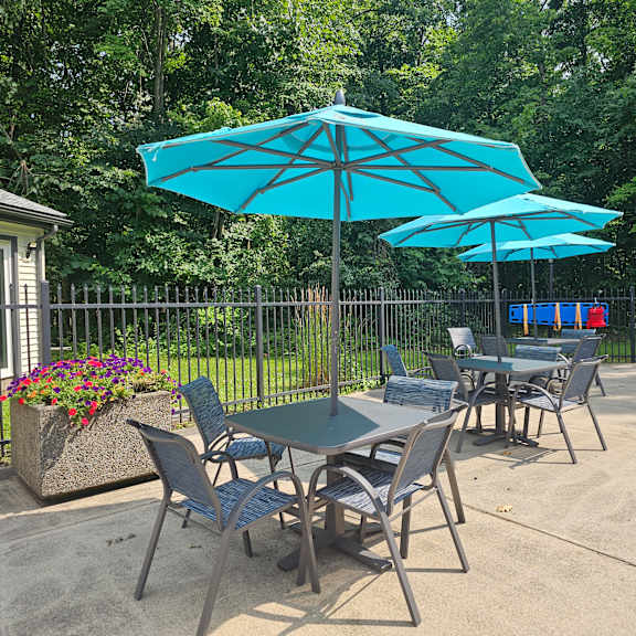 a table and chairs set up under a blue umbrella.