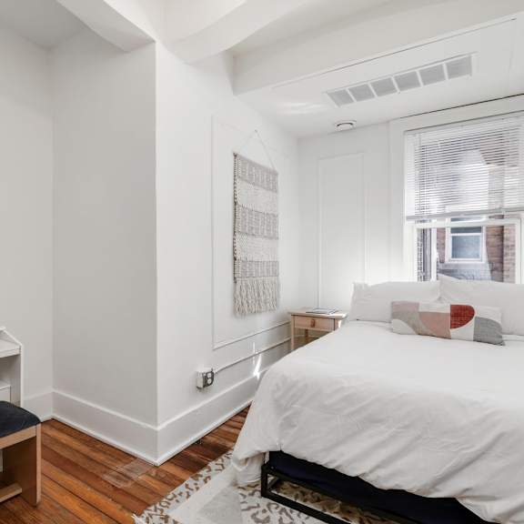 a bedroom with a large bed and a desk with a lamp.