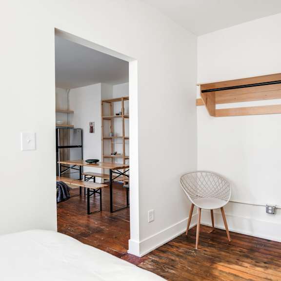 a room with a white chair and a wooden shelf.