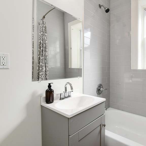 a white sink with a brown bottle on top of it.