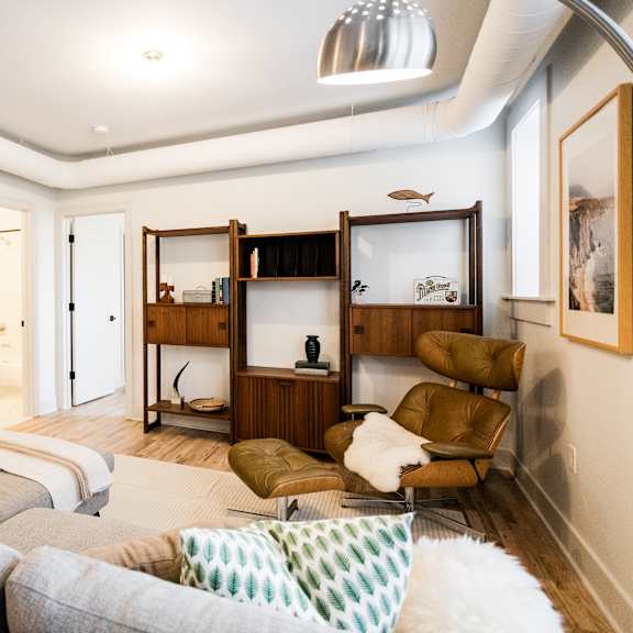 a living room with a grey couch and a white rug.