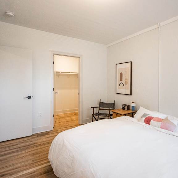 a bedroom with a large bed and a chair.