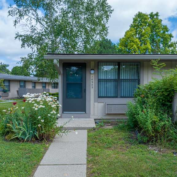 a house with a blue door and a sidewalk in front of it
