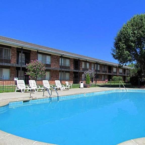a large blue pool in front of a building