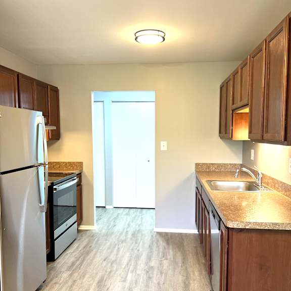 a kitchen with wooden cabinets and stainless steel appliances