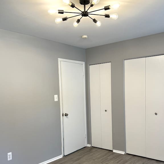 a bedroom with gray walls and a wooden floor