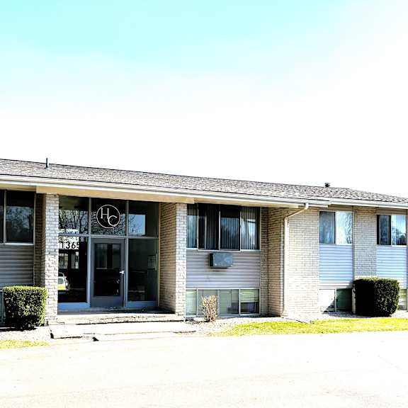 the front of a white building with a black door