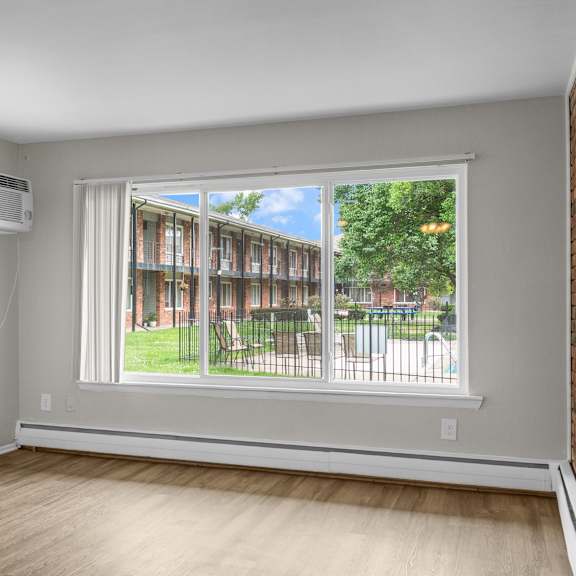 a room with a window showing a view of a residential area.